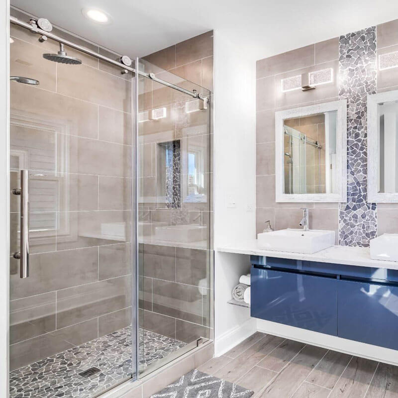 frameless sliding glass shower door with stainless steel hardware in luxury bathroom